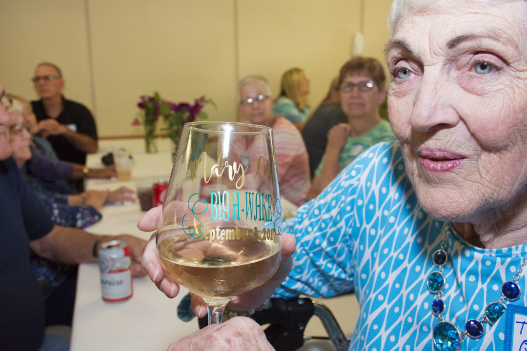 Mary shows off her customized wine glass for her special day, Big A-Wake